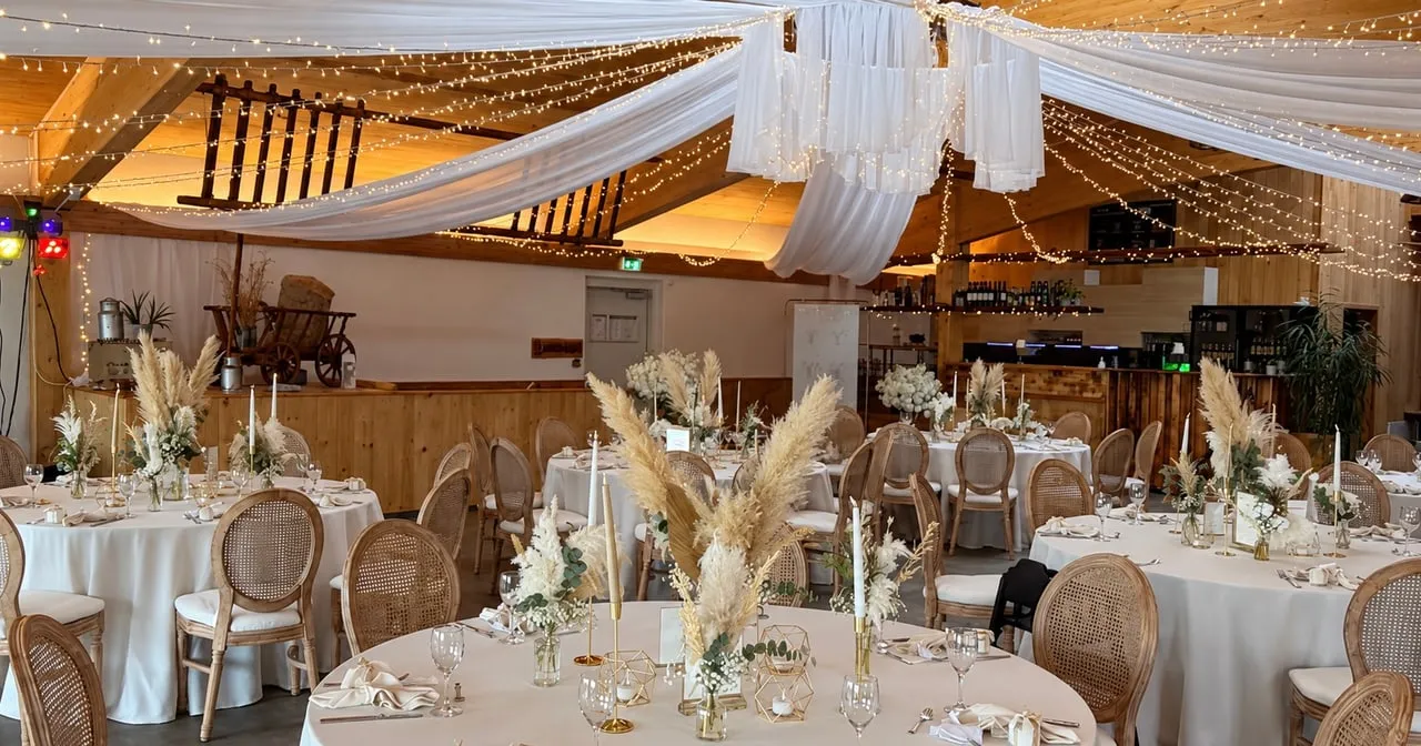 Festsaal mit runden Tischen, Deckendekoration und Pampasgras von Himmelherz Events