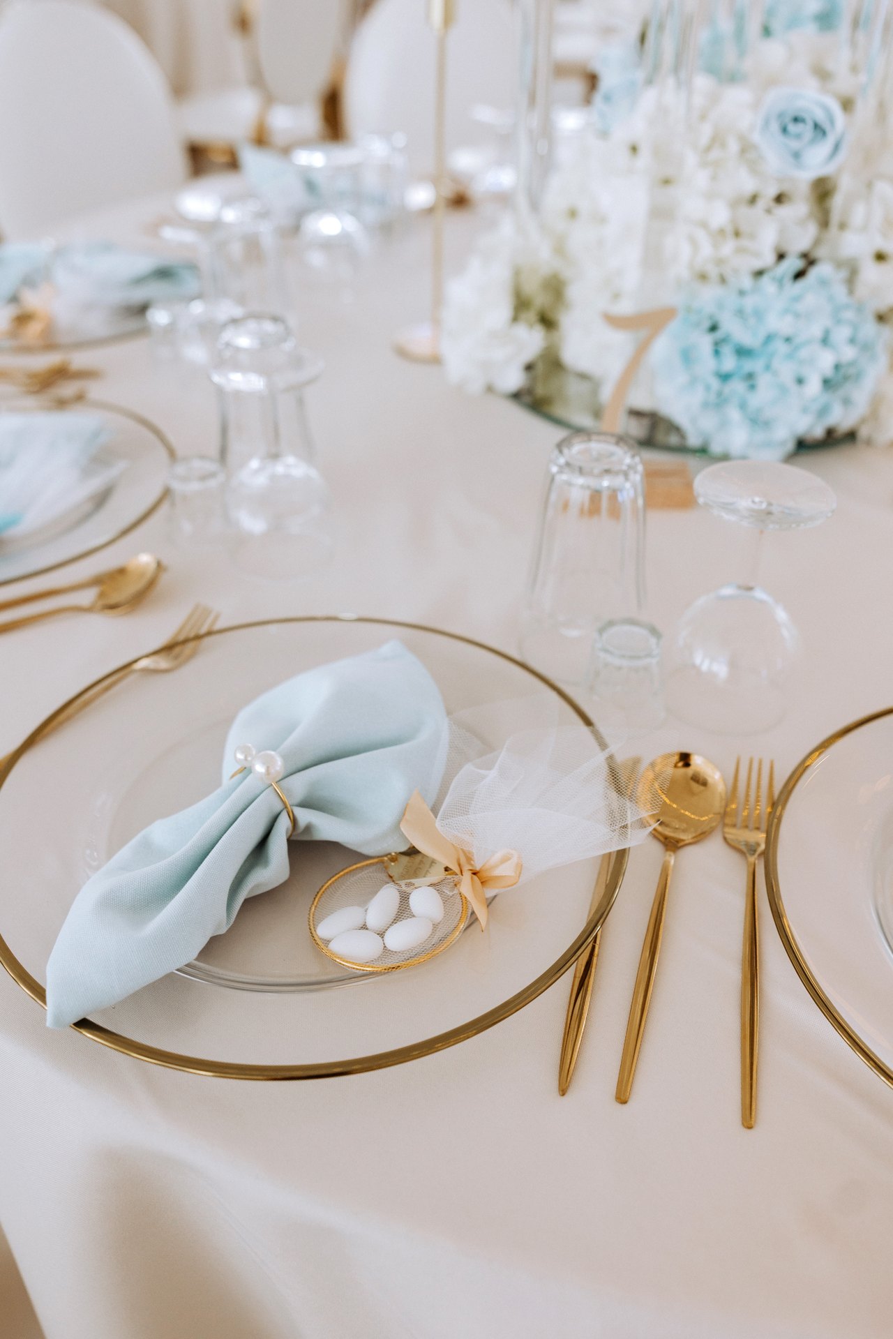 Gedeck mit blauer Serviette und Goldbesteck