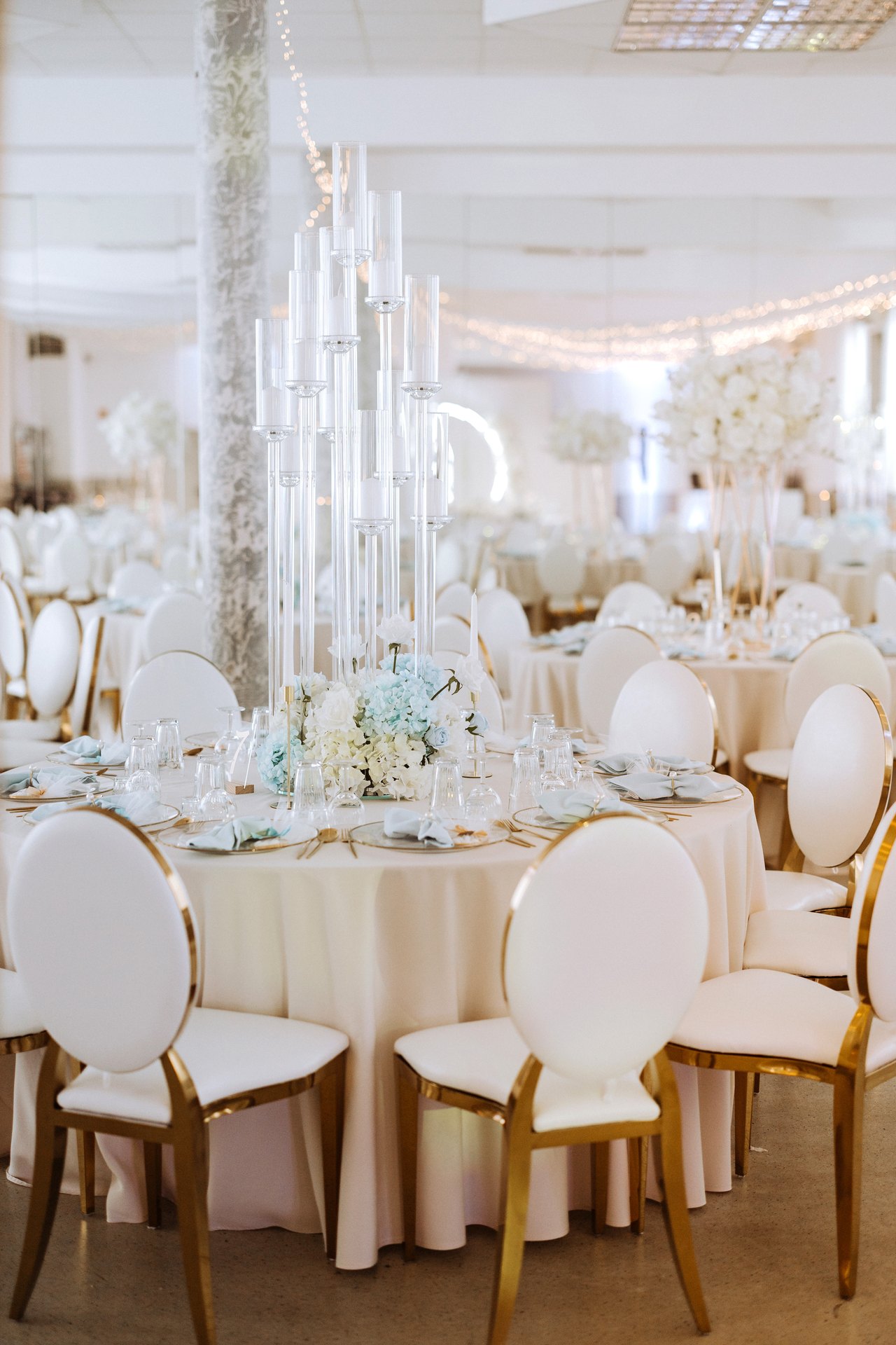 Festsaal mit hohen Blumensäulen und goldenen Stühlen